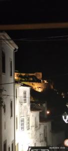 a view of a building at night with a city at Casa do Outeirinho in Castelo de Vide