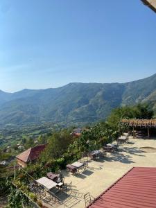 a group of tables and chairs with mountains in the background at Bujtina Shen Meria in Burimas