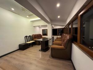 a waiting room with chairs and a table and a tv at Bujtina Shen Meria in Burimas