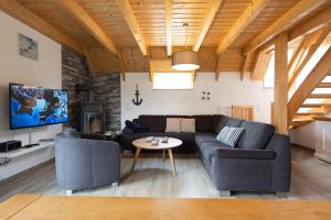 a living room with a couch and a table at Ferienhaus "Happy Krabbe" Mellumplate 31 in Dorum Neufeld