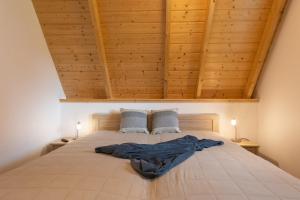 a bedroom with a large bed with two blue pillows at Ferienhaus "Happy Krabbe" Mellumplate 31 in Dorum Neufeld