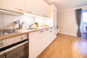 a kitchen with white cabinets and a wooden floor at Appartement "Deichblick" Cappel Whg 10 in Cappel-Neufeld
