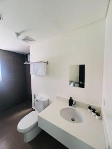 a white bathroom with a toilet and a sink at Levels Executive Residences in Manila