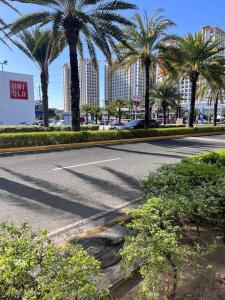 an empty street with palm trees and a hotel at Levels Executive Residences in Manila