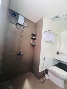 a bathroom with a shower with a toilet and a sink at Levels Executive Residences in Manila