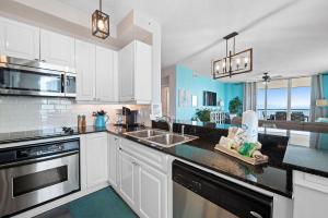 a kitchen with white cabinets and a counter top at Beach Colony East 14D in Pensacola