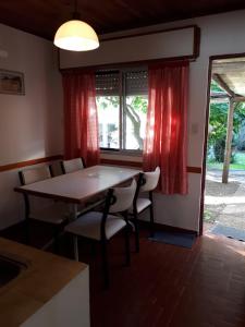 a dining room with a table and chairs and a window at Los Picaflores in Colón