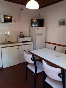 a kitchen with a table and a white refrigerator at Los Picaflores in Colón +3 photos