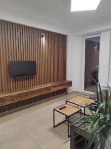 a lobby with a flat screen tv on a wooden wall at Alexandria Lux Apartments in Karpoš Dva