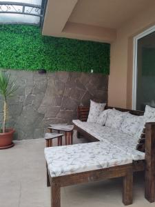 a room with a couch and a stone wall at Alexandria Lux Apartments in Karpoš Dva