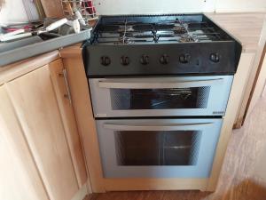 a stove top oven in a kitchen next to a sink at Sunrise Caravan in Dymchurch