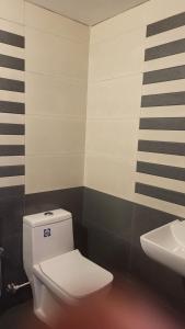 a bathroom with a white toilet and a sink at Happy Seas Beach Villa in Alleppey
