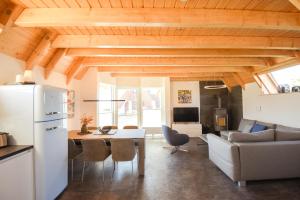 a kitchen and living room with a table and a refrigerator at Ferienhaus Mellumplate 23 in Dorum Neufeld +34 photos