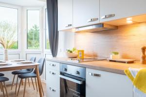 a kitchen with white cabinets and a table and chairs at Appartement "Wattenruh" Cappel Whg 4 in Cappel-Neufeld