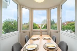 a dining room with a table and chairs and windows at Appartement "Wattenruh" Cappel Whg 4 in Cappel-Neufeld +13 photos