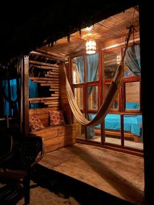 a room with a hammock in a house at Chill and Surf Mendihuaca in Santa Marta