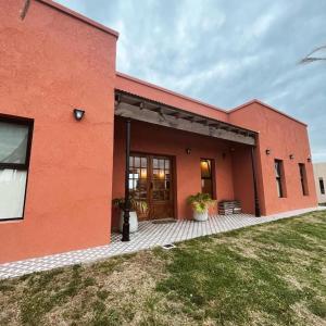 Un edificio rojo con una puerta grande y un patio. en Terramar, en Las Toninas
