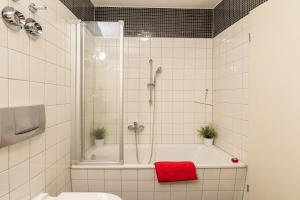 ein Badezimmer mit Dusche und Badewanne mit einem roten Handtuch in der Unterkunft Gemütliches kleines Apartment in Dresden + 21 Fotos