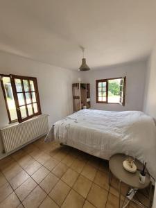 Un dormitorio con una cama y una mesa y dos ventanas. en Secret Escape, en Gardefort 45 fotos más