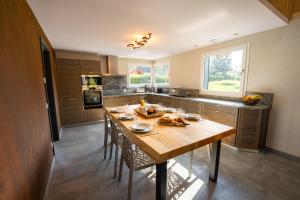 Una gran cocina con una mesa y sillas de madera. en Chalet némésia avec spa à Gérardmer, en Gérardmer