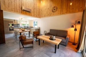 una sala de estar con un sofá y una mesa en Chalet némésia avec spa à Gérardmer, en Gérardmer