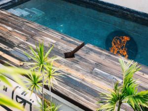 a wooden bench sitting next to a swimming pool at Hotel Sin Nombre in Oaxaca City