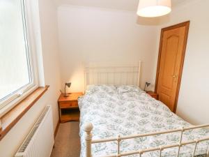ein Schlafzimmer mit einem Bett und einem Fenster in der Unterkunft Hedgehogs Cottage in Glenrothes