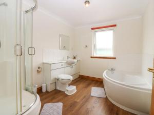 ein Badezimmer mit Badewanne, Toilette und Waschbecken in der Unterkunft Hedgehogs Cottage in Glenrothes + 16 Fotos