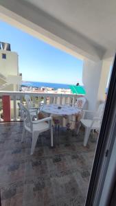 a balcony with a table and chairs and a view of the ocean at Apartmani Šušanj in Bar