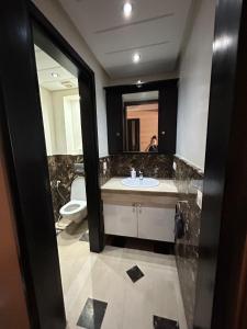 Un baño con lavabo, inodoro y espejo. en Sérénité & Confort - Agadir, en Agadir