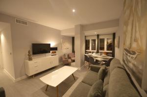 sala de estar con sofá, TV y mesa en Apartamento Victoria, en Cádiz