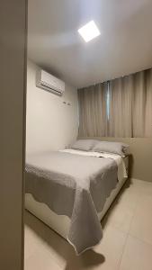 a bedroom with a large bed with a window at Flat Porto Blue 104 - Centro Porto de Galinhas in Porto De Galinhas