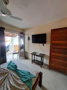 a bedroom with a bed and a flat screen tv at Pousada Aguas Marinhas in Cabo de Santo Agostinho