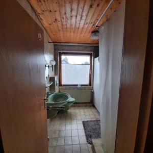a bathroom with a tub and a toilet and a window at LivingRoom GmbH Raf1 Apartment in Salzgitter und Umgebung in Salzgitter