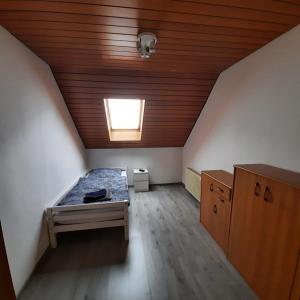 a attic room with a bed and a window at LivingRoom GmbH Raf1 Apartment in Salzgitter und Umgebung in Salzgitter