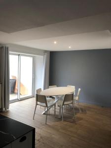 a dining room with a white table and chairs at Charmante maison in Château-Gontier