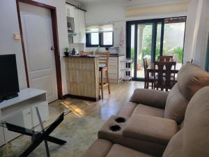 a living room with a couch and a kitchen at Sable Suites C1, 1 Bed Apartments in Kabulonga in Lusaka
