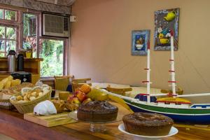 una mesa con un bote de juguete y algo de comida. en Pousada Larimor, en Boicucanga