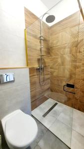 a bathroom with a toilet and a shower at Kwatera Słowackiego - tanie spanie centrum bezpłatny parking in Ełk +14 photos