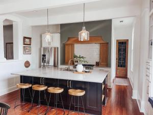 a kitchen with a island with bar stools at Guesthouse on Girod in Mandeville