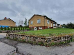 a stone retaining wall in front of a house at Nyrenoverat boende nära Astrid Lindgrens Värld in Vimmerby