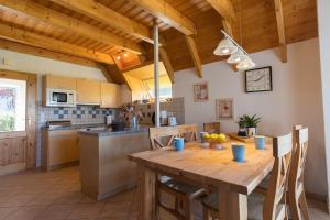 eine Küche mit einem Holztisch mit Stühlen und einem Tisch in der Unterkunft Ferienhaus "Familie Haupt" Mellumplate 48 in Dorum Neufeld