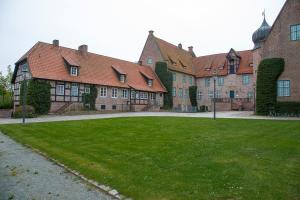 a large building with a green lawn in front of it at Ferienhaus Kiebitzmoor 7 in Bad Bederkesa