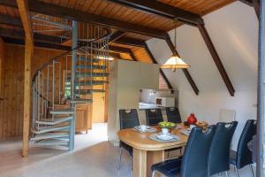 a kitchen and dining room with a wooden table and chairs at Ferienhaus Robbenplate 11 in Dorum-Neufeld