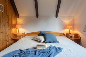 a bedroom with a bed with books and two lamps at Ferienhaus Robbenplate 11 in Dorum-Neufeld
