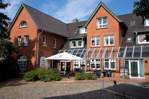 a large brick building with a table in front of it at Cuxlandhotel Doppelzimmer 118 in Dorum Neufeld
