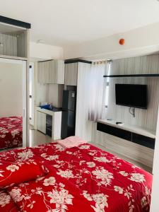 a bedroom with a red bed with a red comforter at Apartemen urban town by NN Room in Karawang