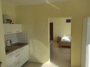 une cuisine avec des armoires blanches et un lit dans une chambre dans l'établissement Swineminde Polen ! Apartament Rent Polen Świnoujście, à Ahlbeck