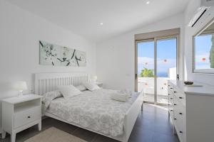 Un dormitorio blanco con una cama y una ventana. en Villa Caterina, Luxury Villa with Heated Pool Ocean View in Adeje, Tenerife, en Adeje 32 fotos más