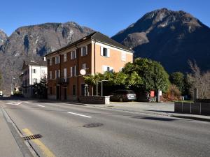 a building on the side of a street with a mountain at Bed and Breakfast da Käthy Agriturismo in Grono